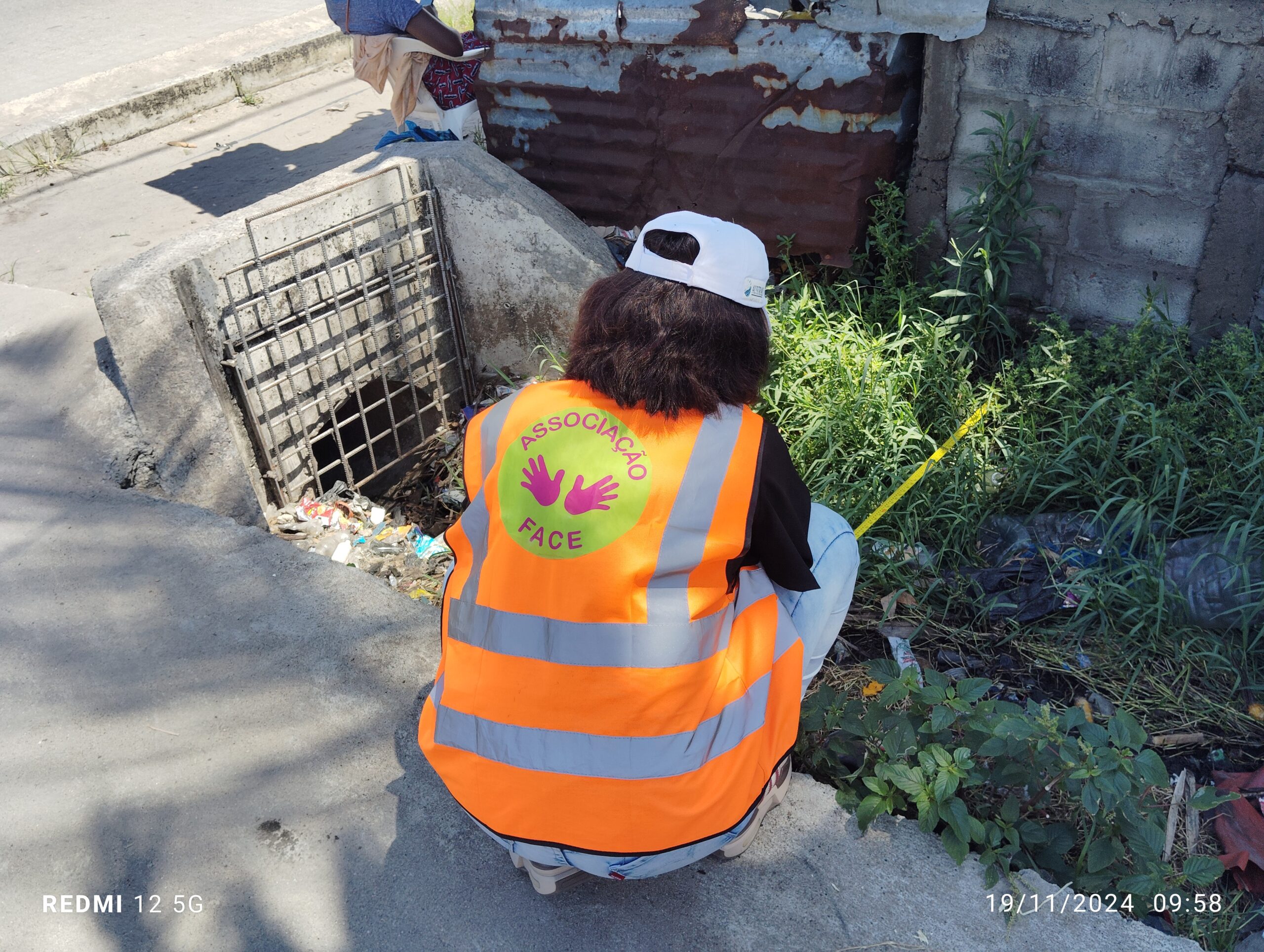 Técnica da Associação FACE a medir uma vala terciária na Cidade da Beira